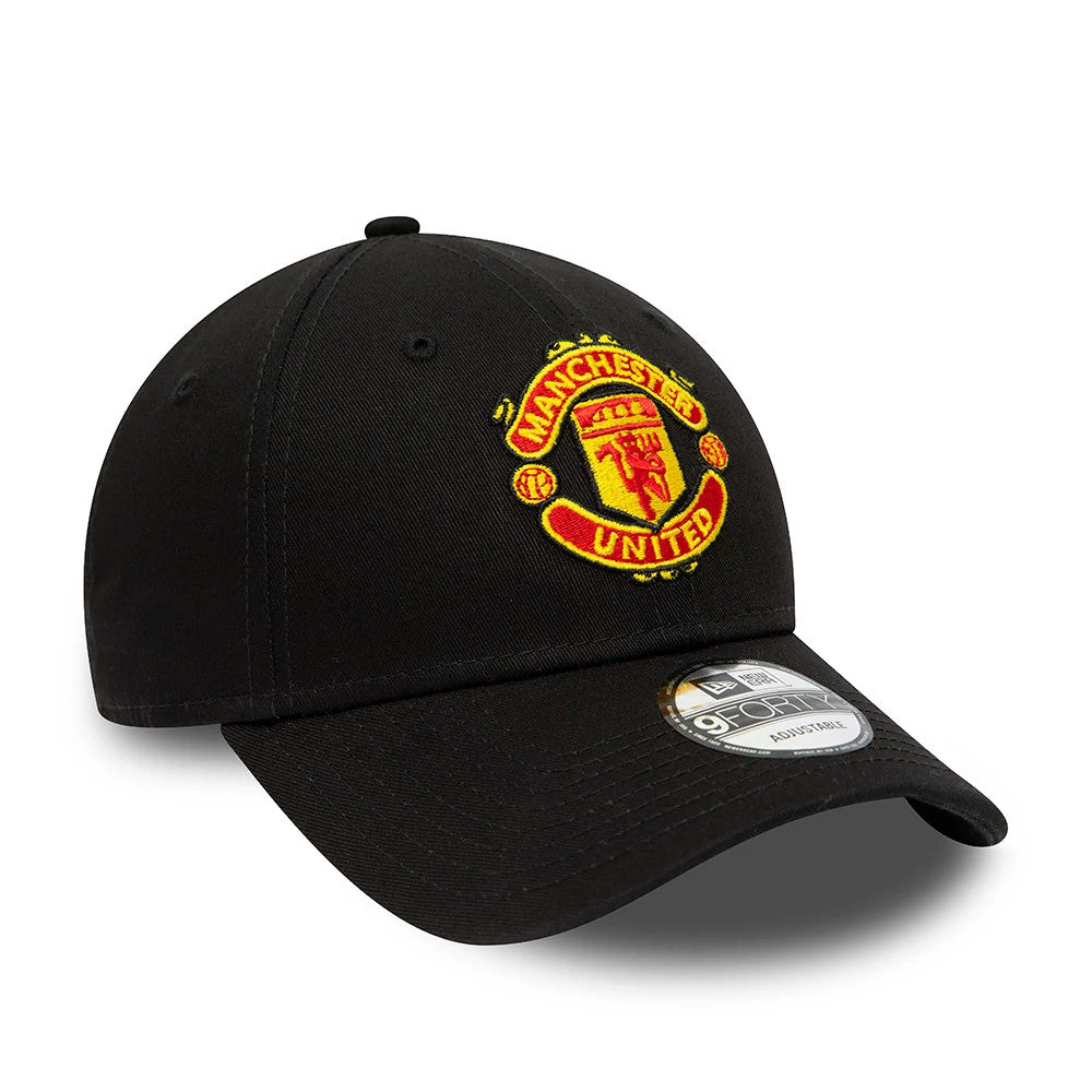 Manchester United FC Youth Core Black New Era 9FORTY Adjustable Cap, front view showing the red and yellow embroidered club crest on the front panel, with a curved visor and 9FORTY size sticker on top.