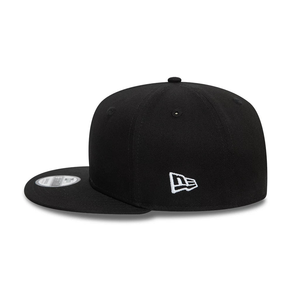 New Era All Black New Era 9FIFTY Cap, side view showing the white New Era flag logo embroidered on the left side, a structured black crown and a flat visor with the 9FIFTY size sticker on top.