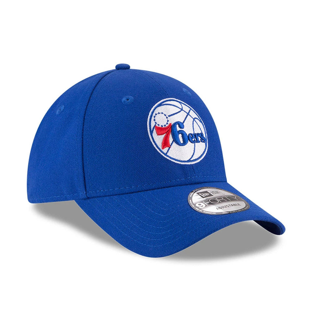Philadelphia 76ers The League Blue New Era 9FORTY Cap, three-quarter view showing the raised team logo in red, white, and blue embroidery on the front panel, with a curved visor and 9FORTY size sticker on the top.