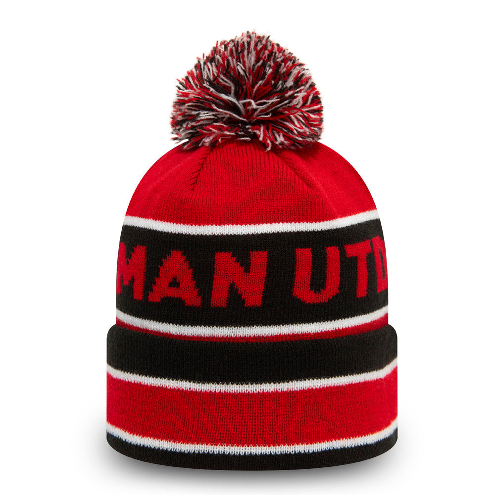 Manchester United Striped Red Multi Bobble Beanie Hat, front view showing a red and black striped design with Manchester Utd text in bold across the centre, topped with a red, black, and white mixed yarn bobble.