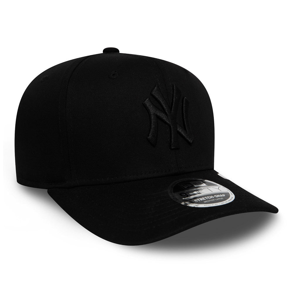 New York Yankees Tonal Black New Era 9FIFTY Stretch Snap Cap, three-quarter view showing a black NY logo in raised embroidery on the front panel and a 9FIFTY size sticker placed on the black visor.