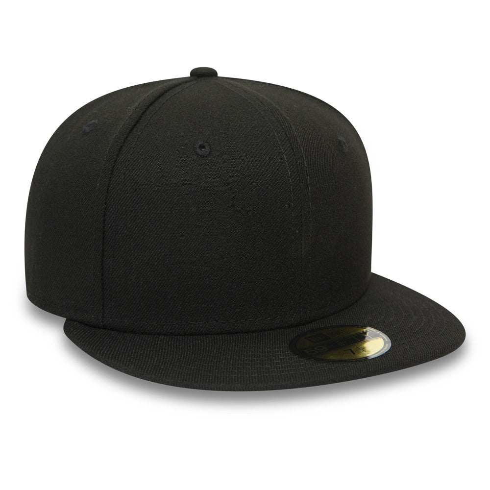 New Era Blank Essential Black 59FIFTY Fitted Cap, three-quarter view showing the structured black crown and flat black visor, complete with a gold 59FIFTY size sticker on top of the visor.