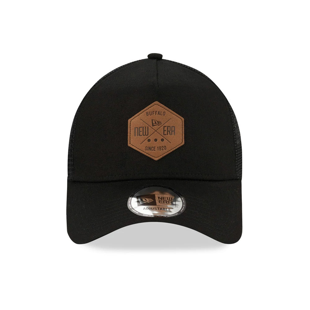 New Era Patch Black A-Frame Trucker Cap, front view showing a brown hexagon patch with the New Era logo and lettering on the centre of the black crown, paired with a curved visor and a New Era 9FORTY size sticker.