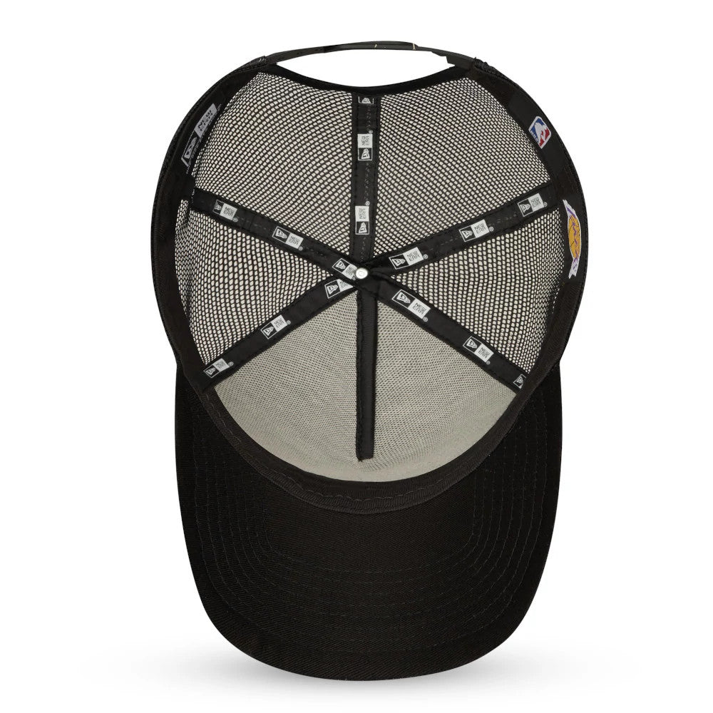 LA Lakers Tonal Black A-Frame Trucker Cap, inside view showing the black taping with New Era logos, a black sweatband, and a mesh crown for breathability, with the top button visible from the underside.