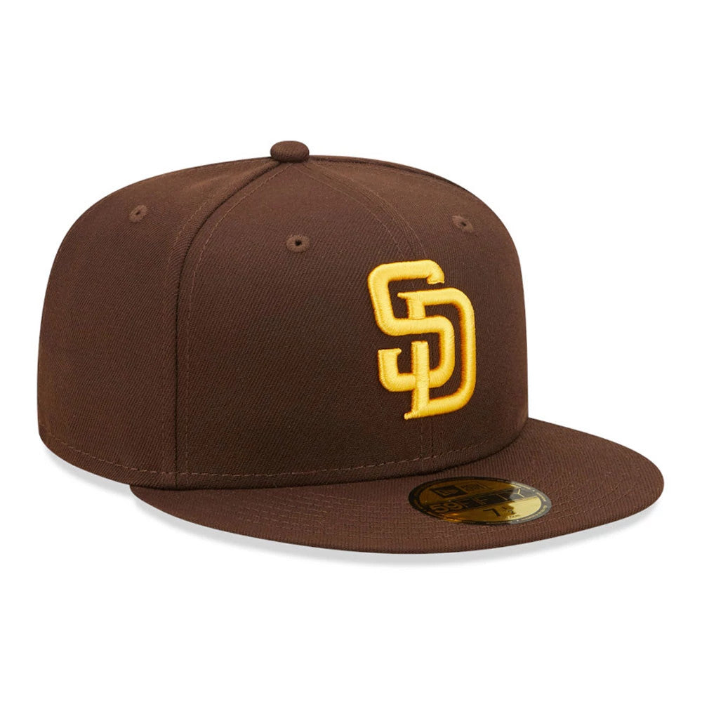 San Diego Padres Authentic On Field Brown New Era 59FIFTY Cap, three-quarter view showing a raised gold SD logo on the front panel, a matching brown flat visor, and the gold 59FIFTY size sticker placed on top of the visor.