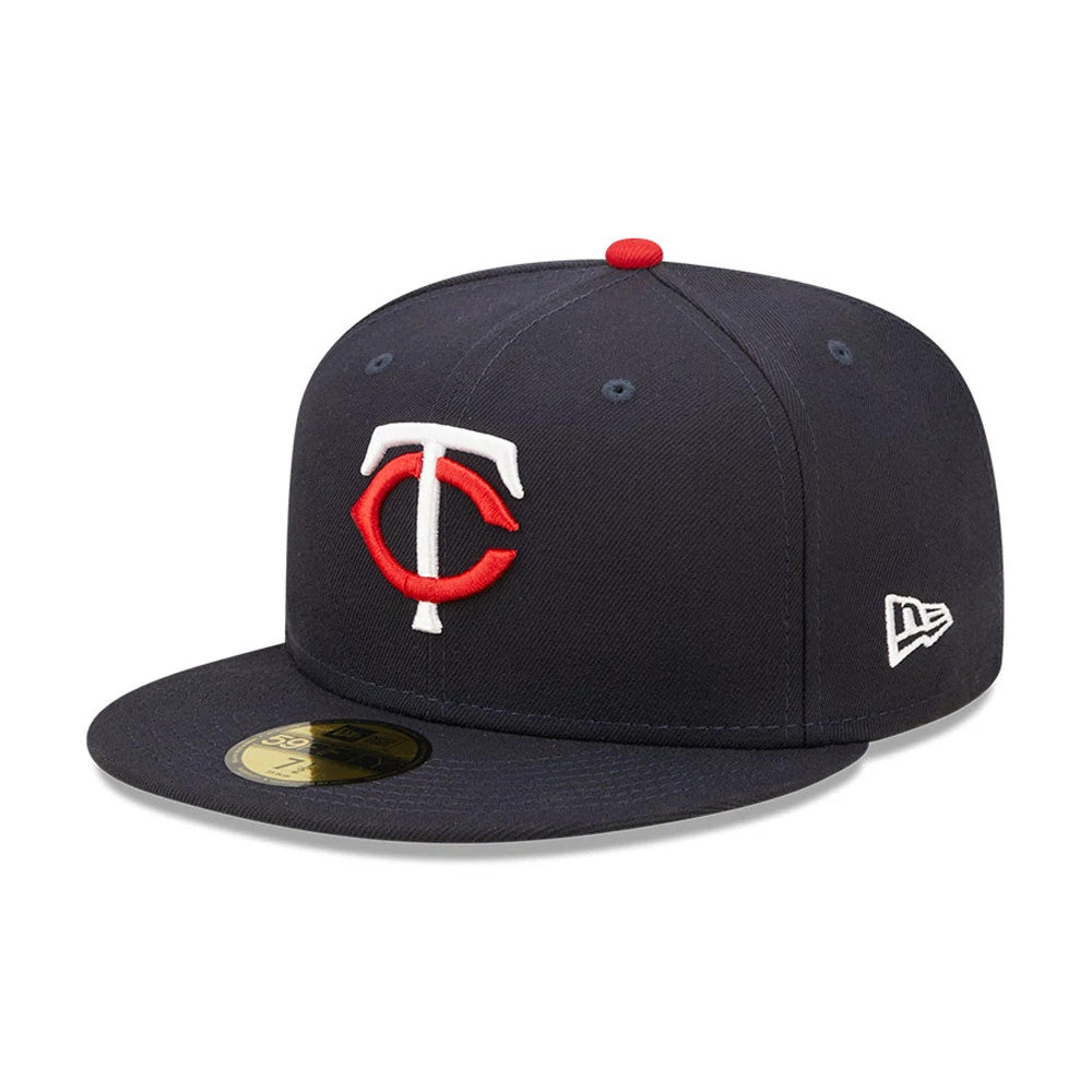 Minnesota Twins Authentic On Field Navy New Era 59FIFTY Cap, three-quarter view showing the raised red and white embroidered TC logo on the front panel, navy flat visor with gold 59FIFTY size sticker, and the New Era flag logo on the left side.