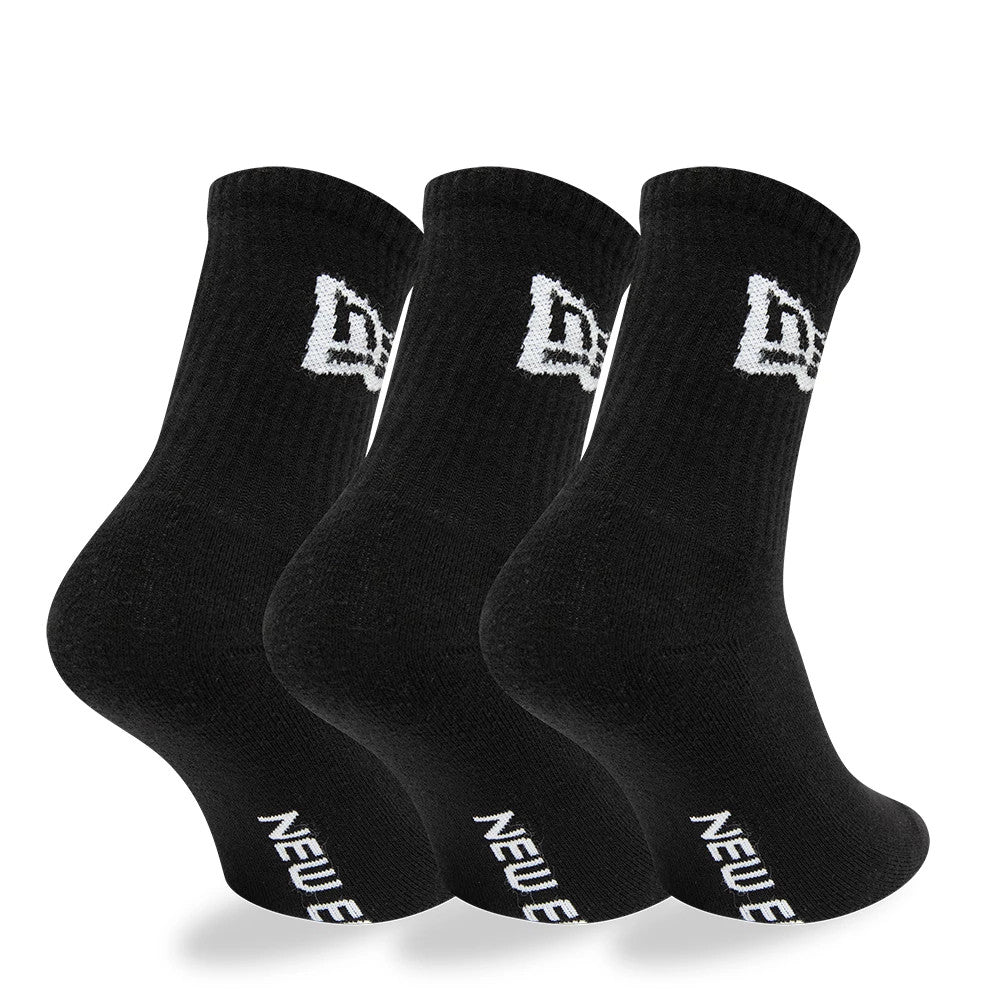 New Era Flag 3 Pack Crew Black Socks, side view showing three pairs of black socks standing with ribbed cuffs, a white embroidered New Era logo near the top and a white "New Era" text on the sole.