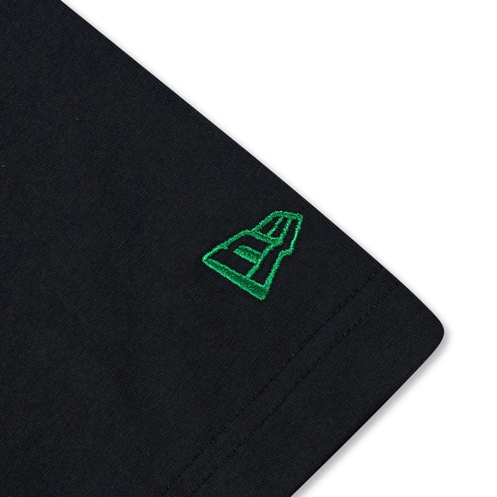 New Era Outdoor Earth Day Black T-Shirt, angled view showing the edge of the black fabric with a green embroidered New Era logo situated near the corner, highlighting the minimalist detail on the garment.