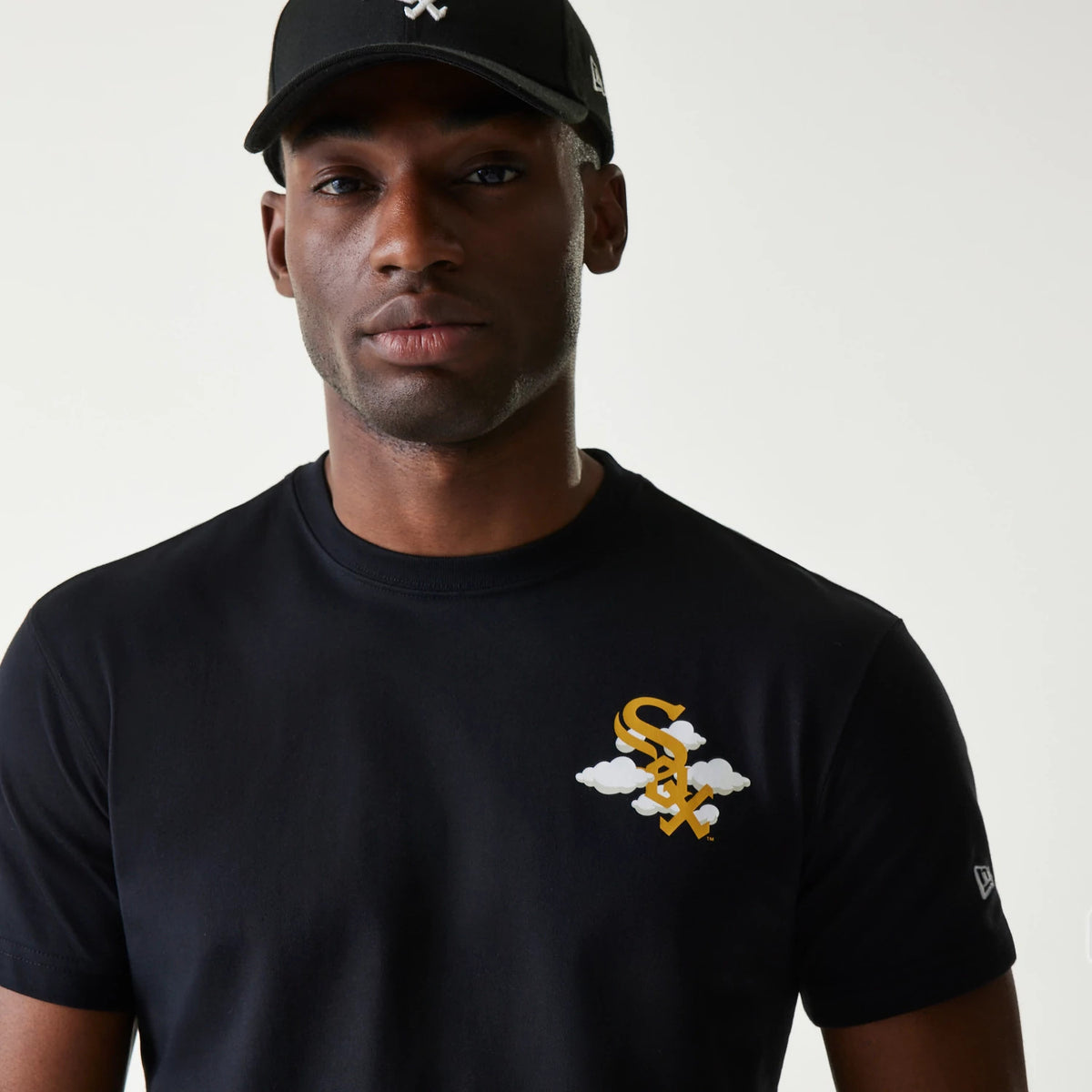 Chicago White Sox MLB 59FIFTY Pack Cloud Black T-Shirt, front view showing a gold and white Sox logo with cloud detail on the left chest and a small New Era logo debossed on the sleeve, worn by a model in a black cap.