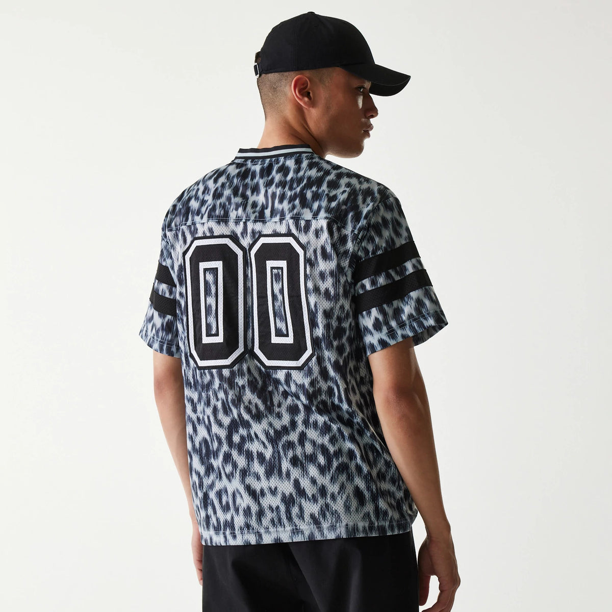 New Era Retro Sports Grey Mesh Jersey, back view on a model wearing a dark cap, featuring bold black and white "00" numbering across the upper back and dark double stripes on the sleeves.