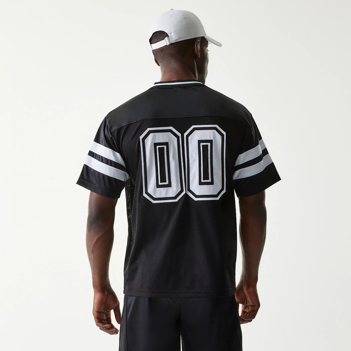 New Era Retro Sports Black Mesh Jersey, back view on a model wearing a white cap, showing '00' lettering centred on the back with white double stripes on the sleeves and a V-neck collar design.