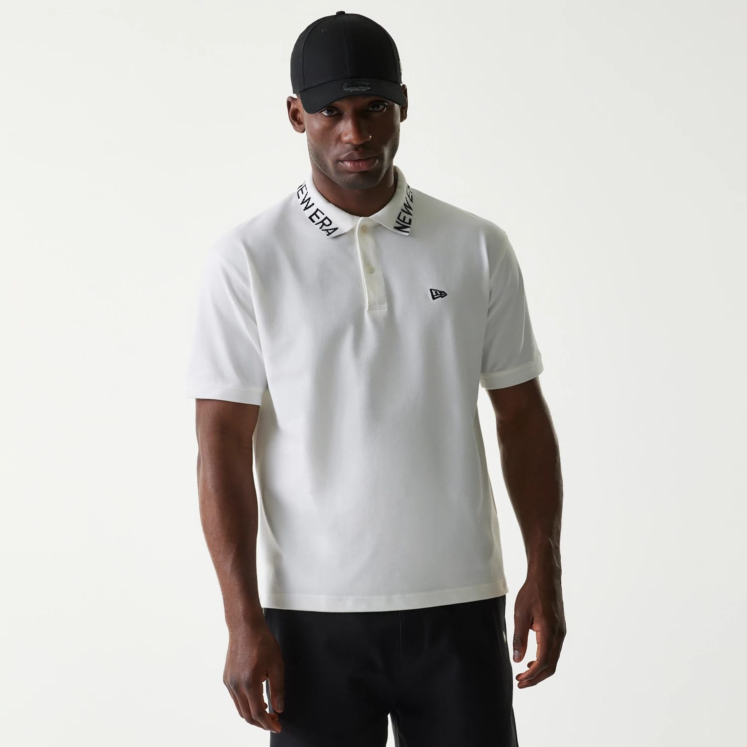 New Era Japan Collar Logo White Polo T-Shirt, on-model view featuring the embroidered New Era logo on the left chest, a white fabric with "NEW ERA" printed on the collar, and short sleeves.