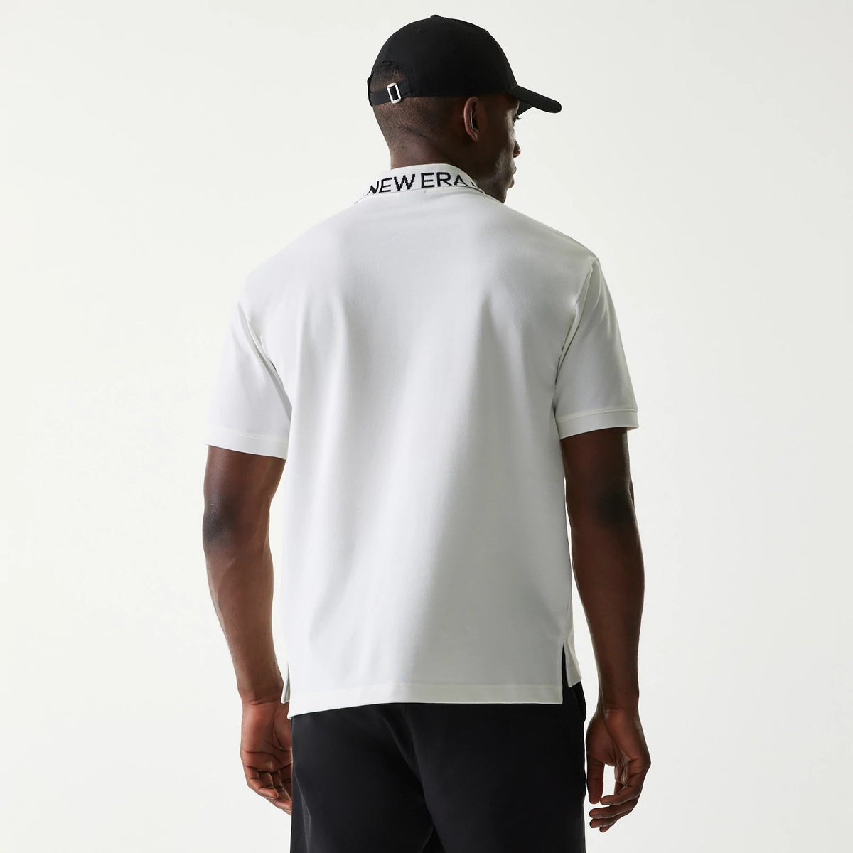 New Era Japan Collar Logo White Polo T-Shirt, on-model rear view showing a plain white back with short sleeves, the collar featuring an embossed black New Era logo across the top edge.