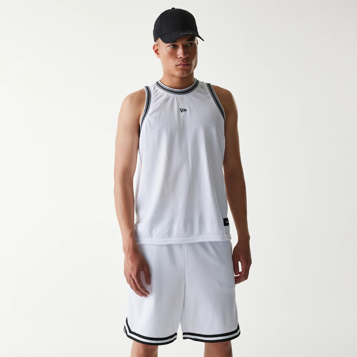 New Era Japan Mesh White Sleeveless T-Shirt, on-model view showing a man wearing the white sleeveless t-shirt with black trim around the neck and armholes, a raised New Era logo on the chest, paired with matching white shorts.