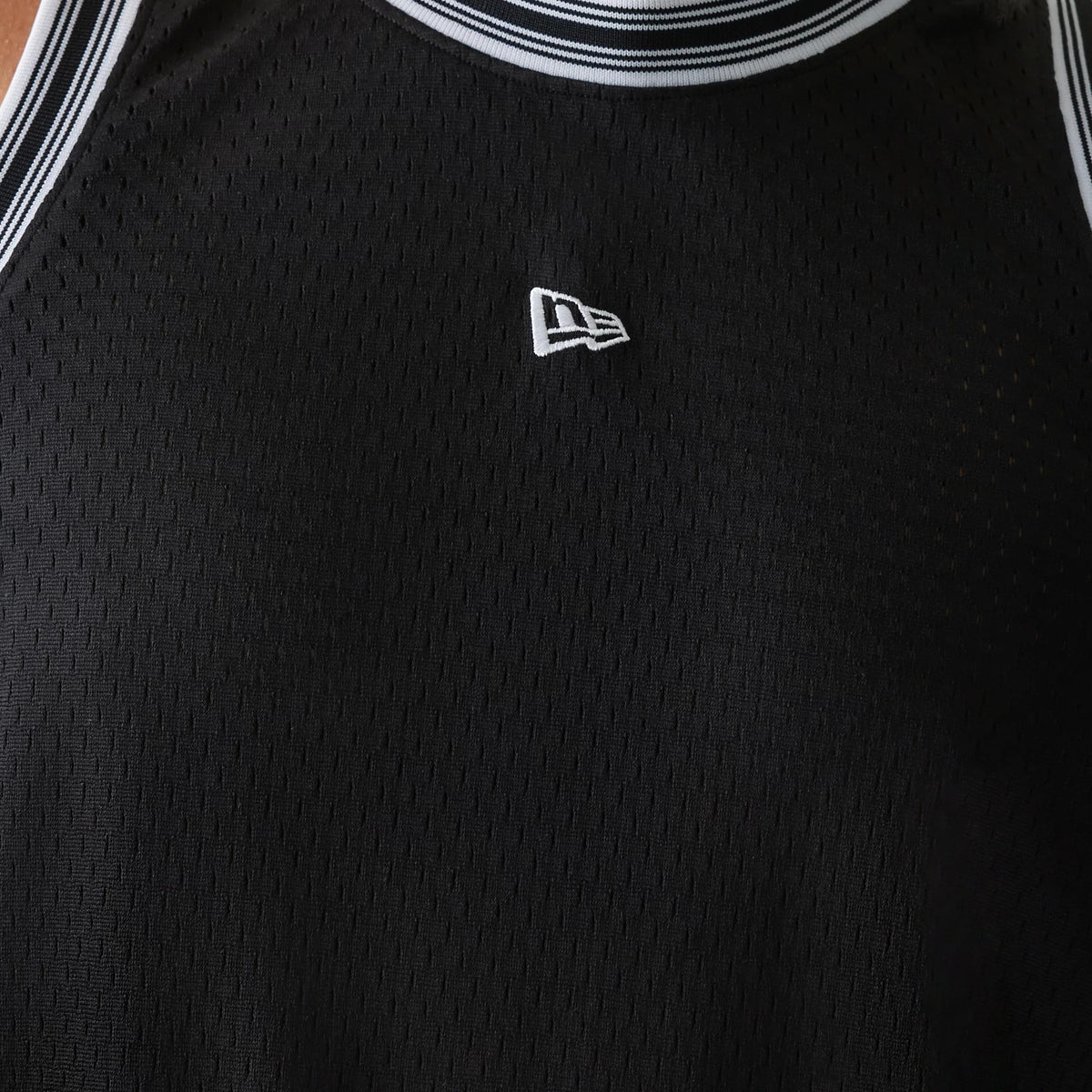 New Era Japan Mesh Black Sleeveless T-Shirt, front view showing a black sleeveless design with a raised white New Era logo centred on the upper chest, and white striped trims along the neckline and arm openings.