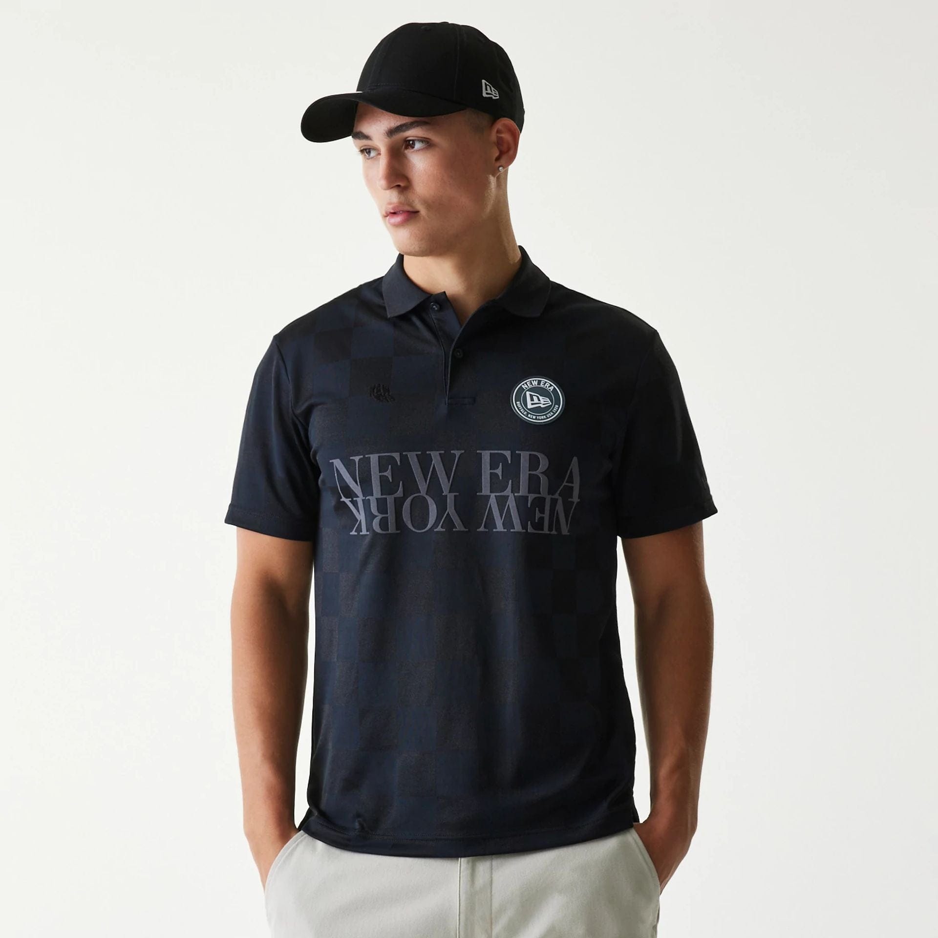 The Male model is wearing New Era Japan Grid Black Polo T-Shirt 1