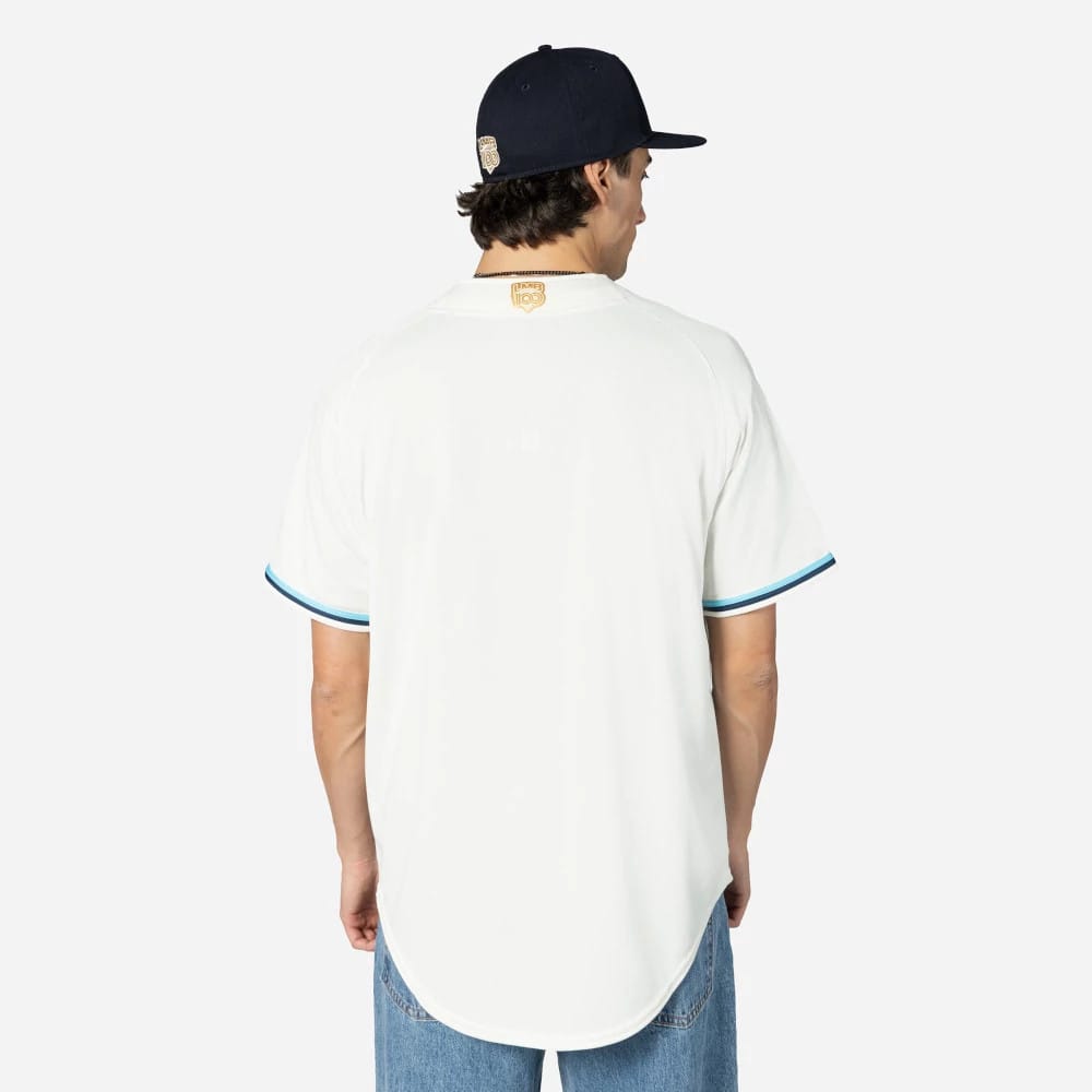 New Era Veracruz Aguilas Mexico LMB On Field Cream On-Field Jersey, back view on a model wearing a black cap, showing the embroidered emblem below the neckline and teal trim on the sleeve cuffs.