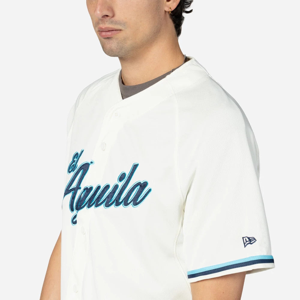 Veracruz Aguilas Mexico LMB On Field Cream On-Field Jersey, side view on a model with a New Era flag logo on the left sleeve and El Aguila script in blue with black outline across the chest.