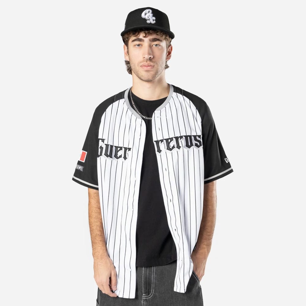 Oaxaca Guerreros Mexico LMB On Field White On-Field Jersey, front view on a model with a pinstripe design, black raglan sleeves, embroidered Guerreros lettering across the chest and a New Era logo on the left sleeve.