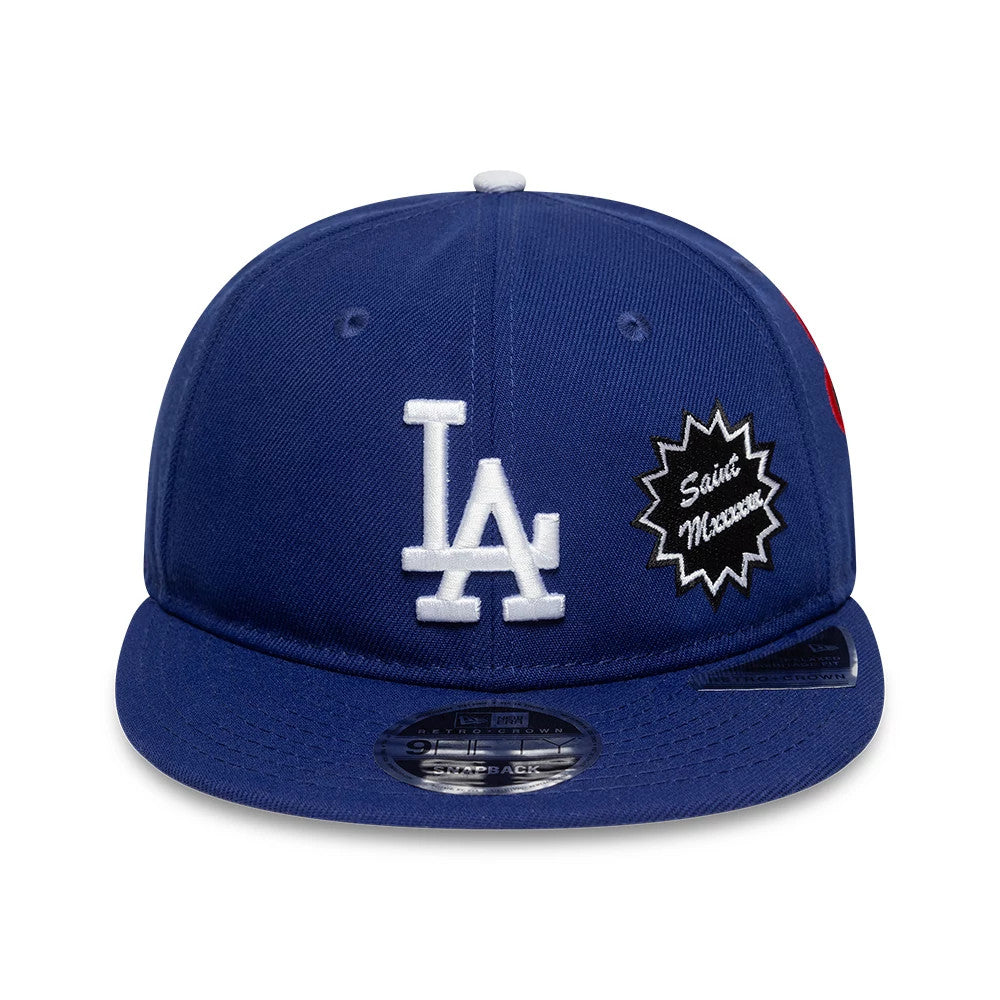 LA Dodgers MLB X Saint Mxxxxxx Dark Blue Retro Crown New Era 9FIFTY Snapback Adjustable Cap, front view with a white LA logo and a black Saint Mxxxxxx patch on the front panel, featuring a 9FIFTY size sticker on the visor.