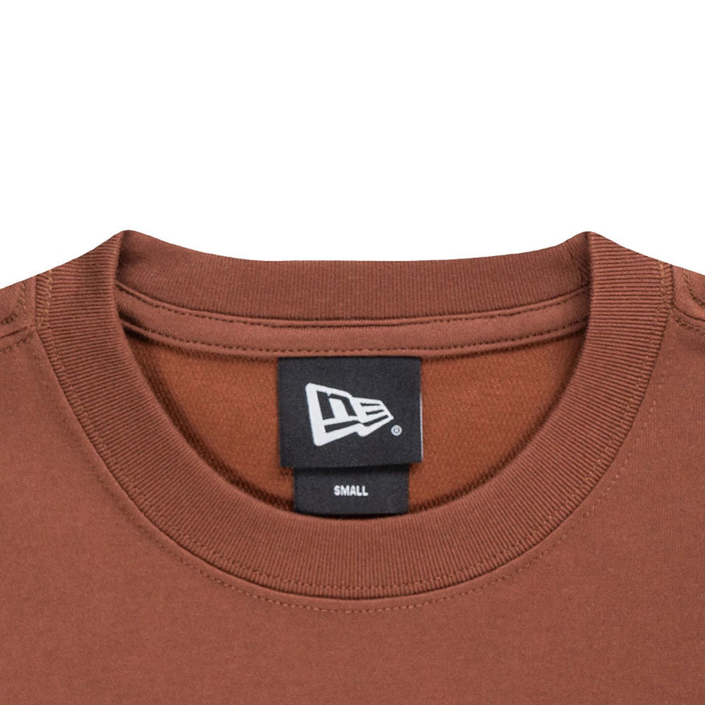 New Era Mountain Logo Open Brown T-Shirt, close-up view showing the ribbed neckline of the brown shirt with a small white embroidered New Era logo on a black tag at the inside back collar.