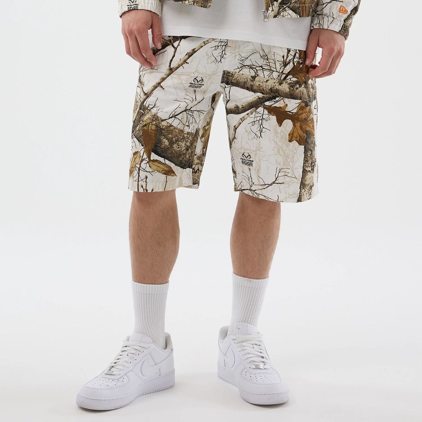 The Male model is wearing New Era Earthy Skin Real Tree Snow Oversized Shorts 7