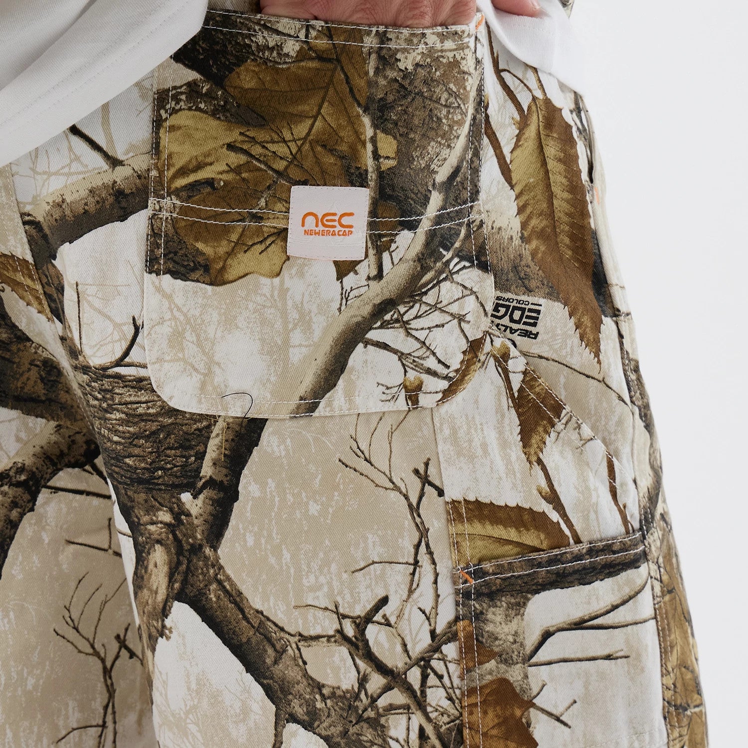The Male model is wearing New Era Earthy Skin Real Tree Snow Oversized Shorts 3