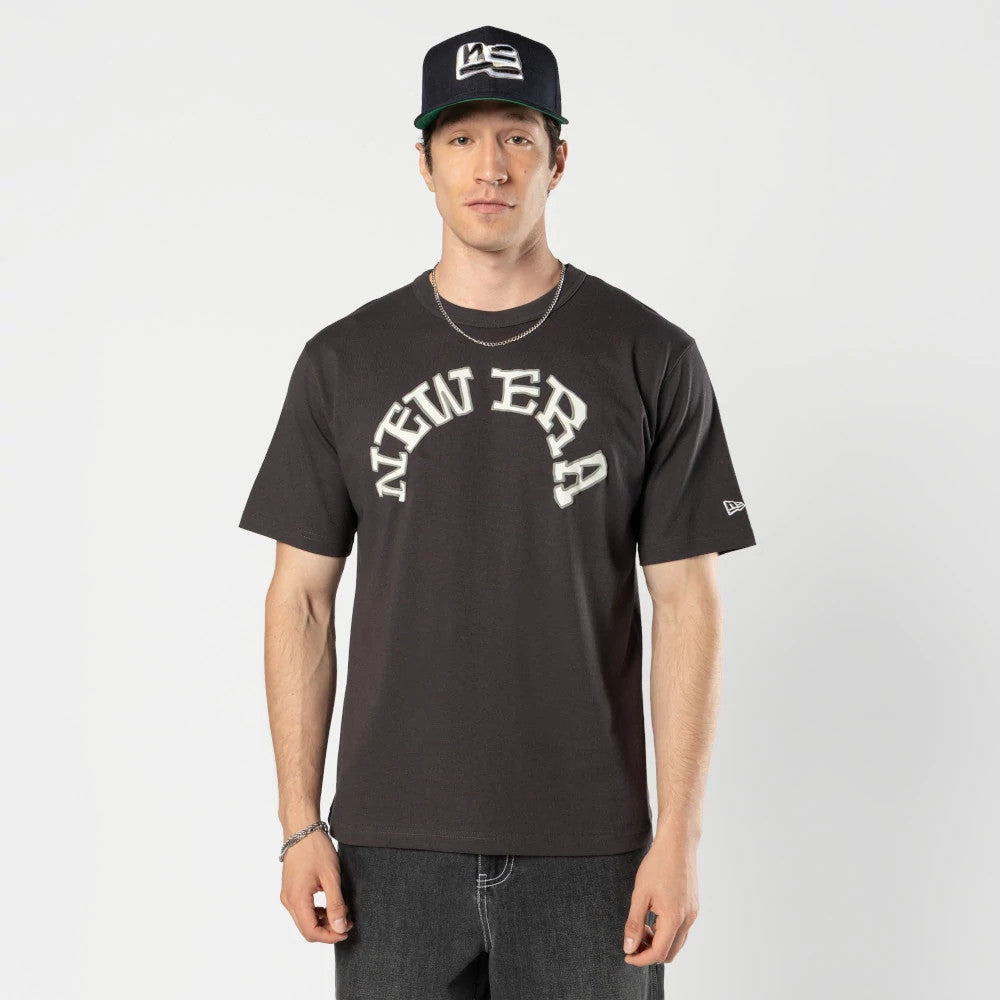 New Era Ochiai Shohei Grey T-Shirt, front view showing the black shirt with large curved white New Era text across the chest and a small embroidered New Era logo on the left sleeve.