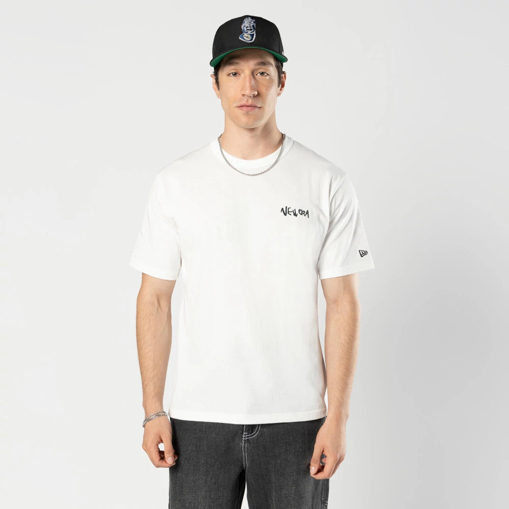 New Era Ochiai Shohei Office Cream T-Shirt, front view showing a cream T-shirt worn with a New Era logo printed on the left chest, a small debossed logo on the left sleeve, and a black cap with a raised emblem.