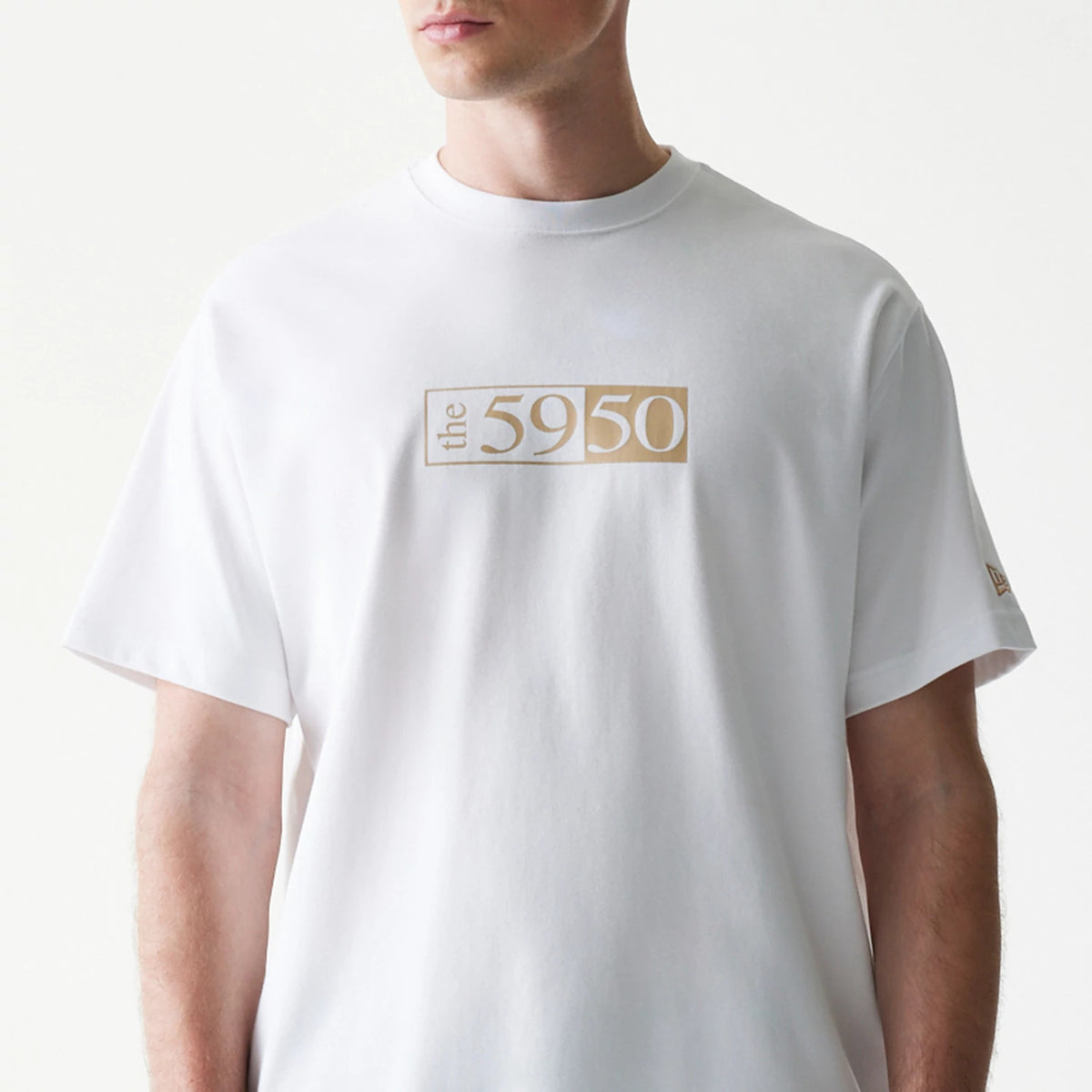 59FIFTY Fitted Cap Description Graphic White T-Shirt, front view showing a beige graphic with the text "the 5950" on the chest and a small debossed New Era logo on the left sleeve.