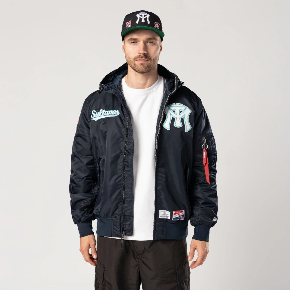 Sultanes De Monterrey LMB X Alpha Navy Jacket, on-model view showing a navy front with a large raised logo on the chest, a smaller script logo on the left, and a zip closure running down the centre.