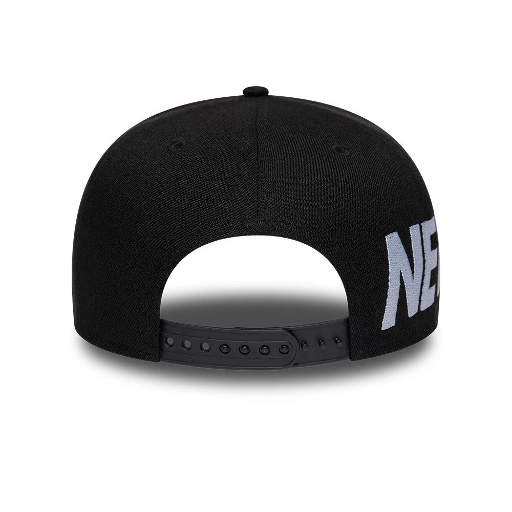 New Era Essential Black 9FIFTY Snapback Adjustable Cap, rear view showing the adjustable snap closure, embroidered lettering on the side, and the structured black crown with a centred top button.
