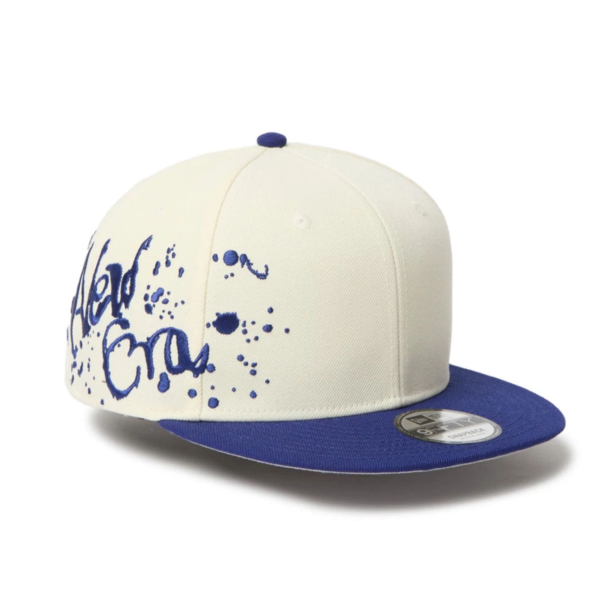 This is a New Era Dripping Emblem Cream 9FIFTY Snapback Adjustable Cap 1
