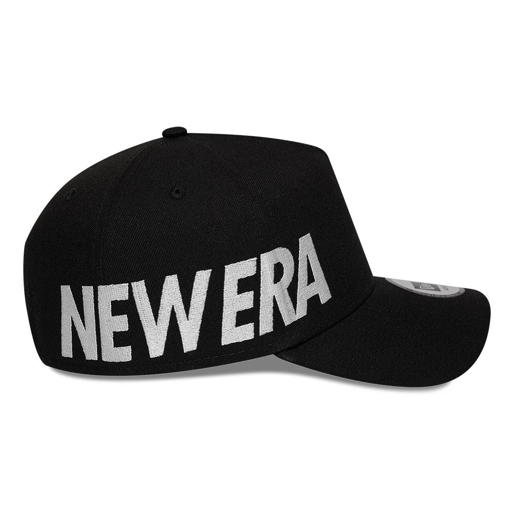 New Era Essential Black 9FORTY A-Frame Adjustable Cap, side view showing bold white New Era lettering embroidered across the left side of the black crown, with a curved visor and 9FORTY size sticker on top.