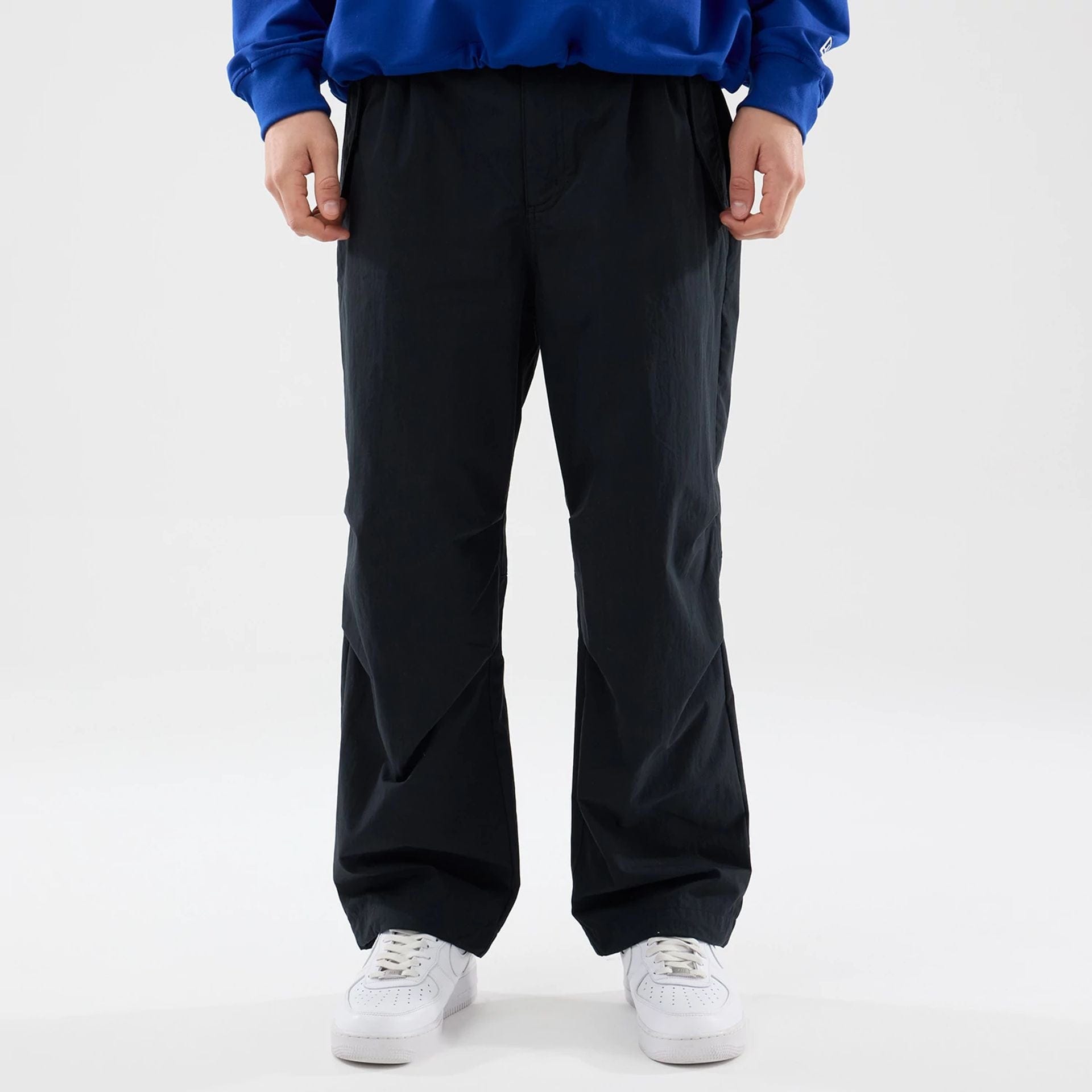 The Male model is wearing New Era Organic Black Parachute Trousers 1