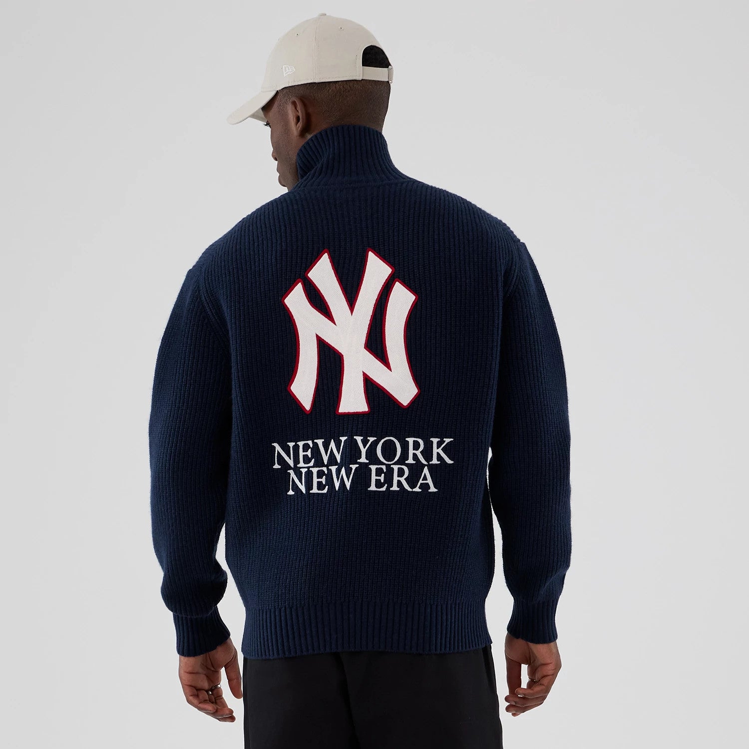 New York Yankees MLB Navy Cardigan, back view on a model, featuring a large white NY logo outlined in red above New York New Era lettering, with a high collar and ribbed knit texture.