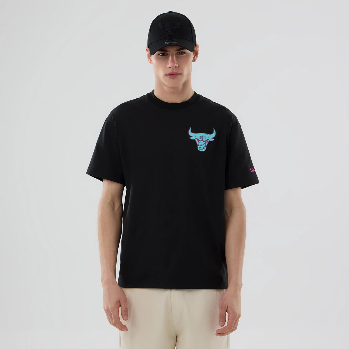 Chicago Bulls NBA Neon Light Black T-Shirt, on-model front view showing a bold neon-style bull logo on the chest, a small embroidered New Era logo on the sleeve, and the plain black fabric of the T-shirt against the light background.