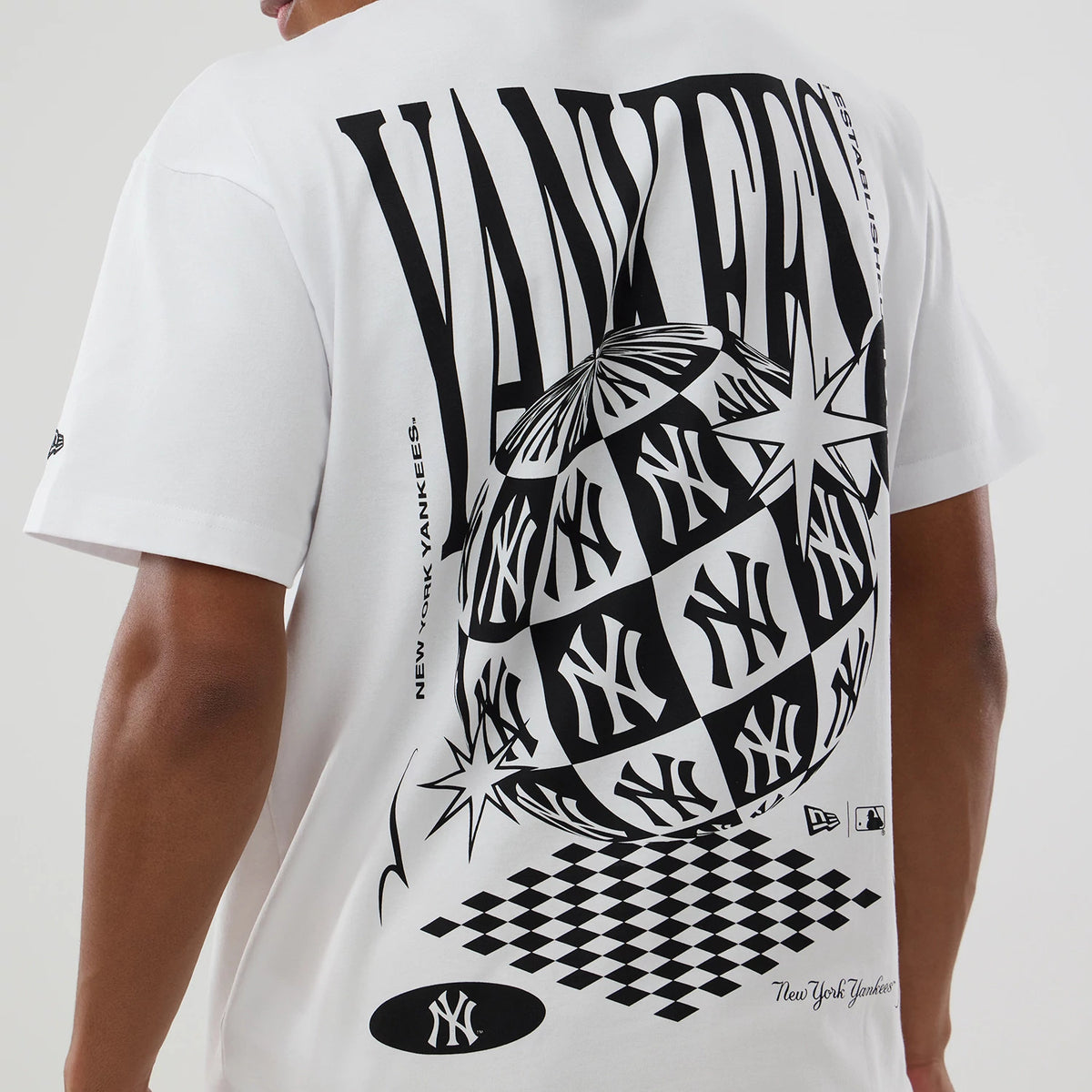 New York Yankees MLB World White T-Shirt, rear view showing a bold black Yankees graphic with stars and checkerboard pattern across the back, a small black debossed New Era logo on the sleeve and script text near the hem.