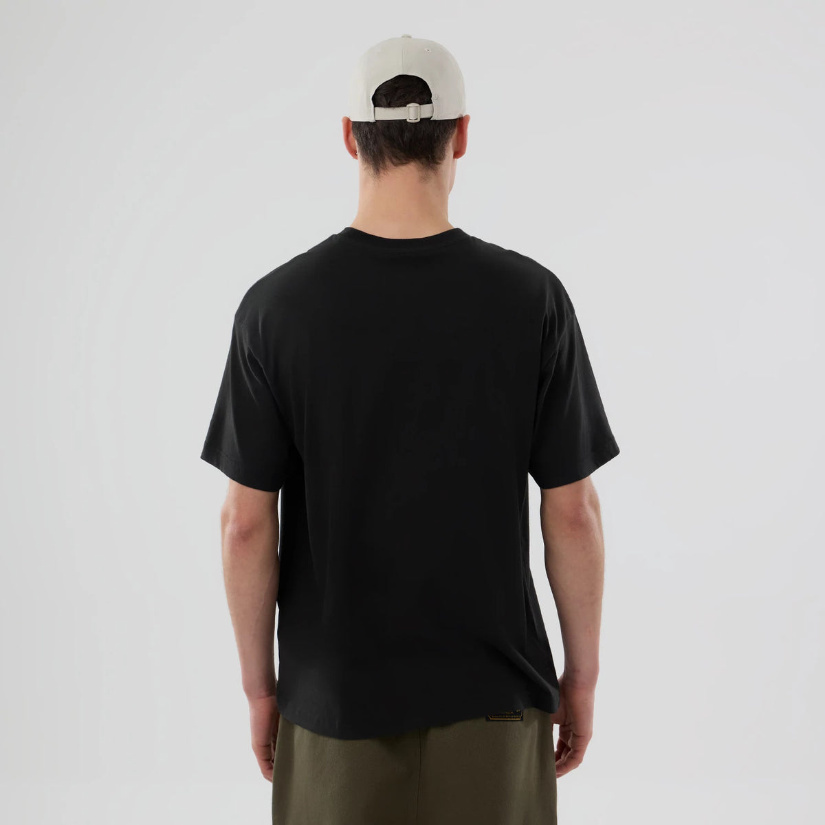 New Era New York Yankees MLB On Fire Black Oversized T-Shirt, rear view showing the plain black back with a relaxed fit on an on-model view, paired with a light grey cap featuring a debossed logo on the back.