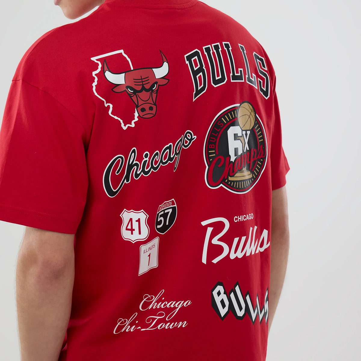 Chicago Bulls NBA logo Red T-Shirt, back view showing multiple printed designs including a bold Chicago Bulls logo, state outline, and script text, with various championship and road sign motifs in white, black, and red.