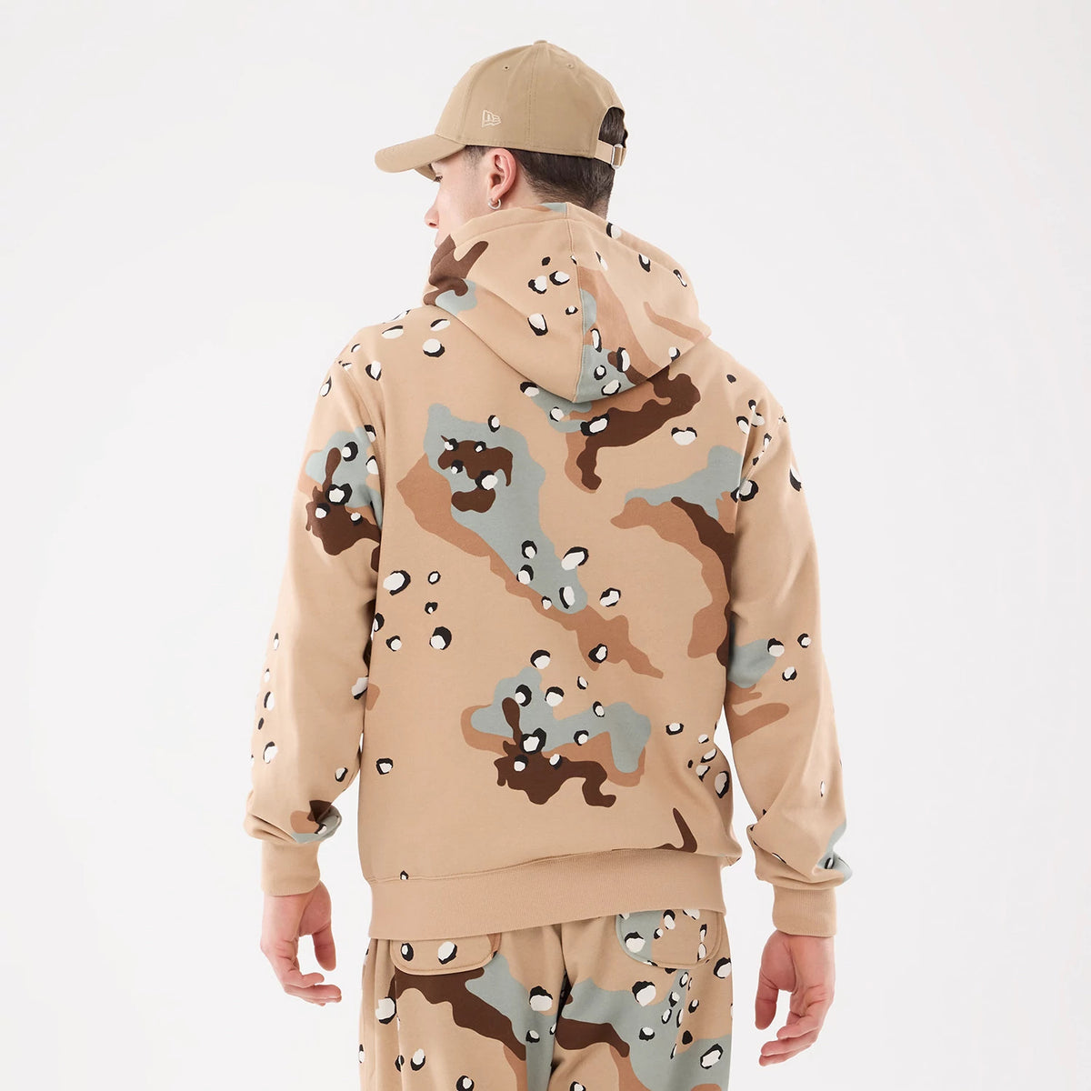 New York Yankees MLB Desert Camo 2 Way Full Zip Hoodie, rear view showing a desert camo pattern in shades of beige, brown, and grey with a raised New Era logo on the side of a beige cap worn by a model.