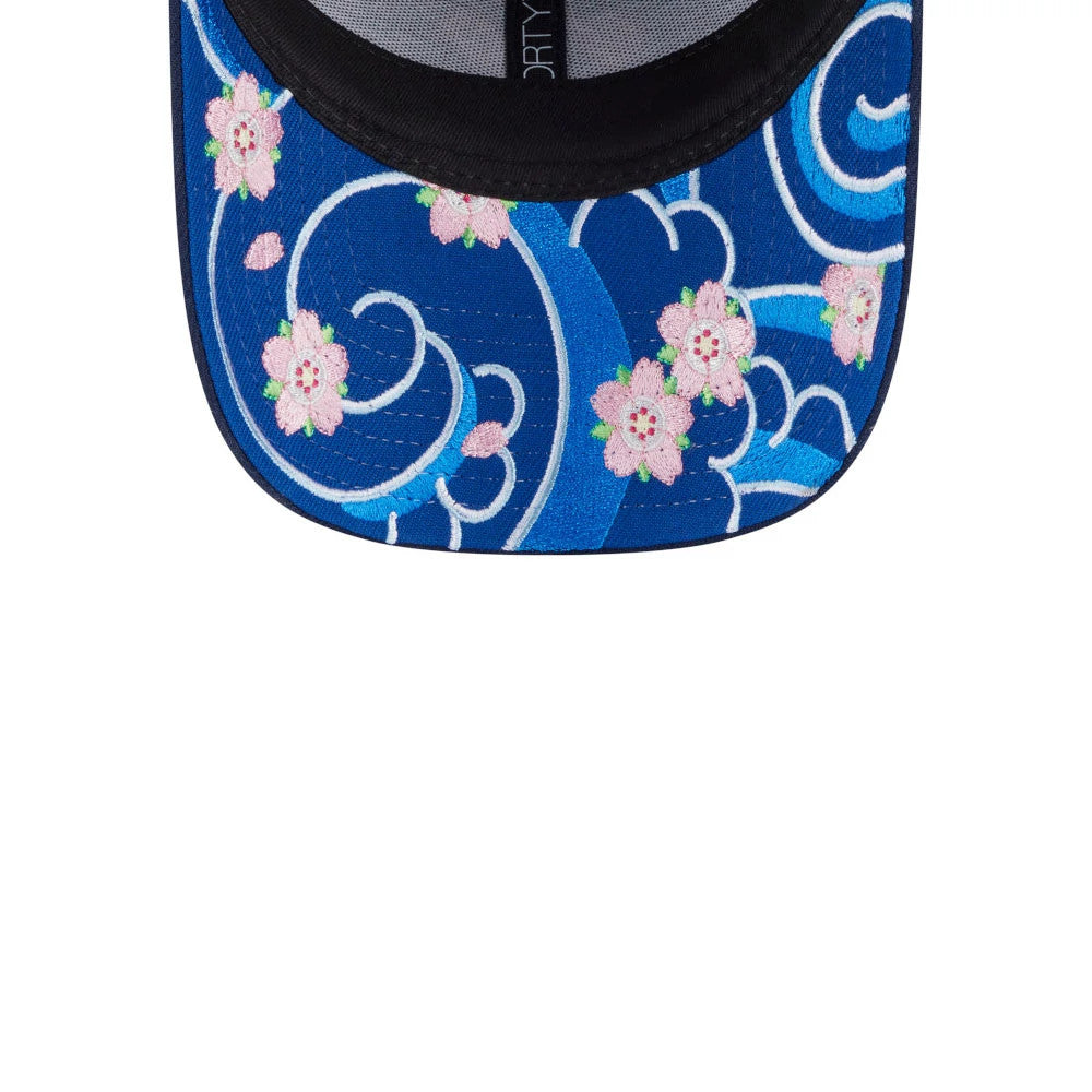 New Era Sakura Dark Blue 9FORTY Adjustable Cap, inside view showing a detailed floral and wave pattern on the undervisor, with light pink cherry blossoms and swirling white lines against a rich blue backdrop.