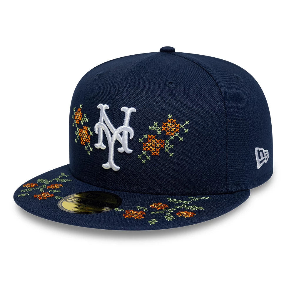 New York Mets MLB Garden Dark Blue New Era 59FIFTY Fitted Cap, three-quarter view showing the white embroidered NY logo on the front panel, with orange and green floral designs on the crown and visor, and a gold 59FIFTY size sticker.