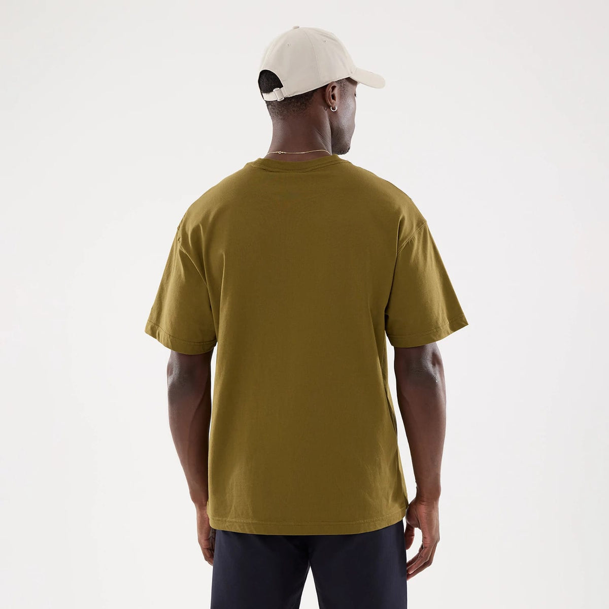 New York Yankees MLB Green T-Shirt, rear view showing the plain green back with short sleeves and a crew neckline, worn by a model also wearing a cream cap featuring an embossed logo on the back.