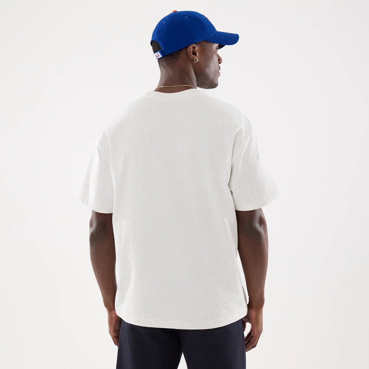 New York Mets MLB Comfort Grey T-Shirt, rear view showing the plain grey fabric with short sleeves, worn by a person in a bright blue cap with a raised New Era logo at the back, against a neutral background.