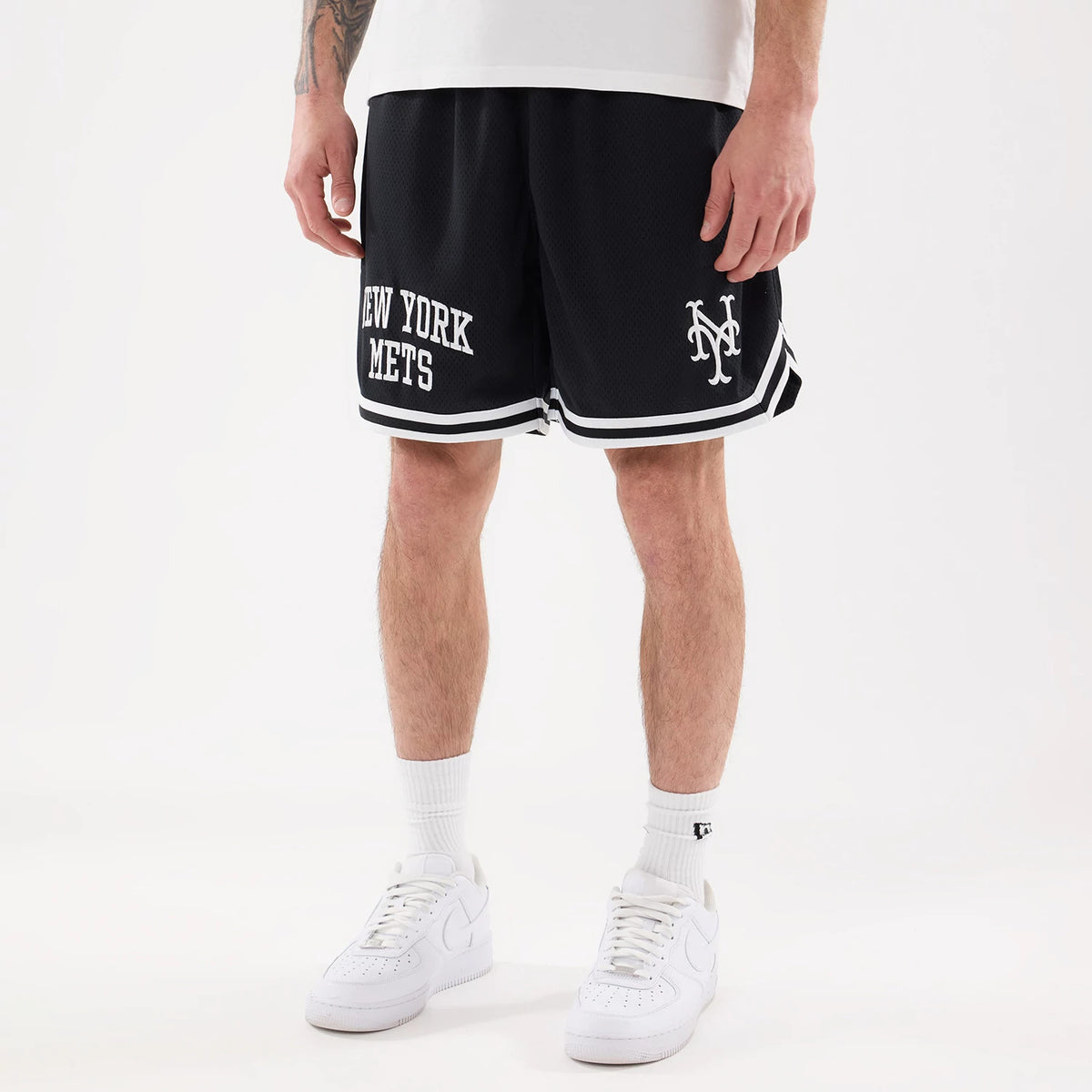 New York Mets MLB Comfort Navy Oversized Shorts, front view showing the navy shorts with white "New York Mets" text on the left leg, an embroidered team logo on the right, and a white striped trim at the hem.