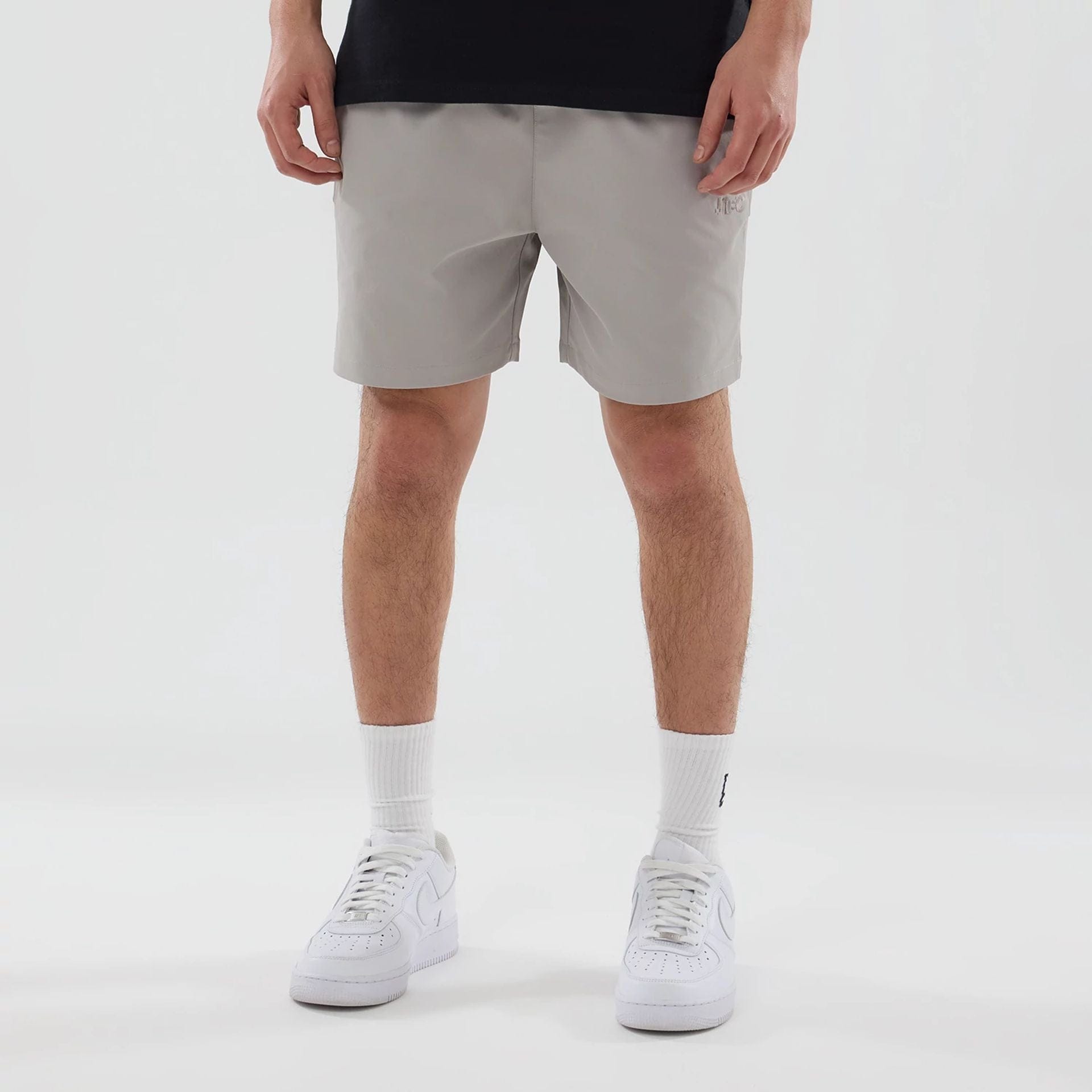 The model is wearing this New Era NEC Logo Oversized Shorts in Beige . 1