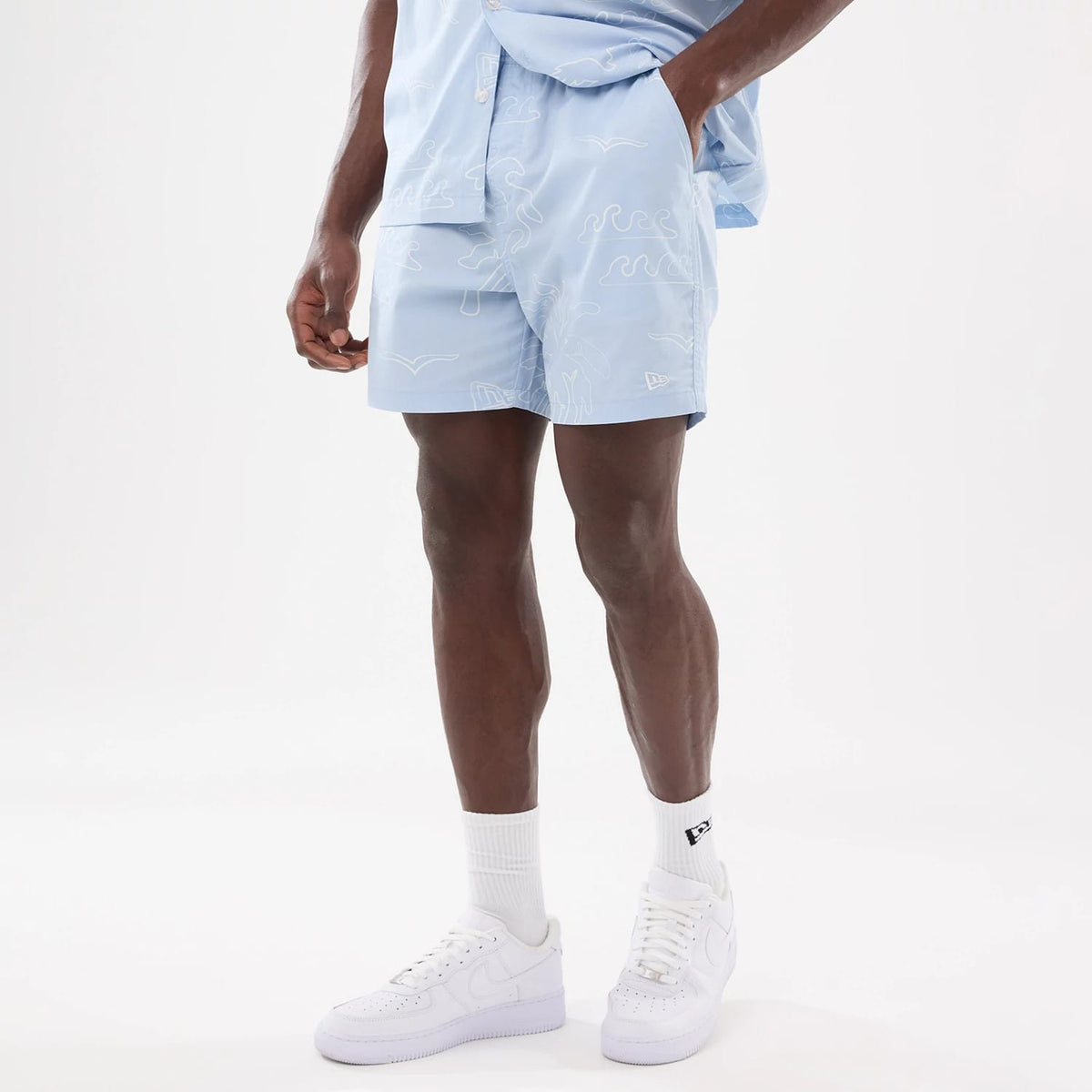 The model is wearing these New Era Resort Oversized Shorts in blue. 8