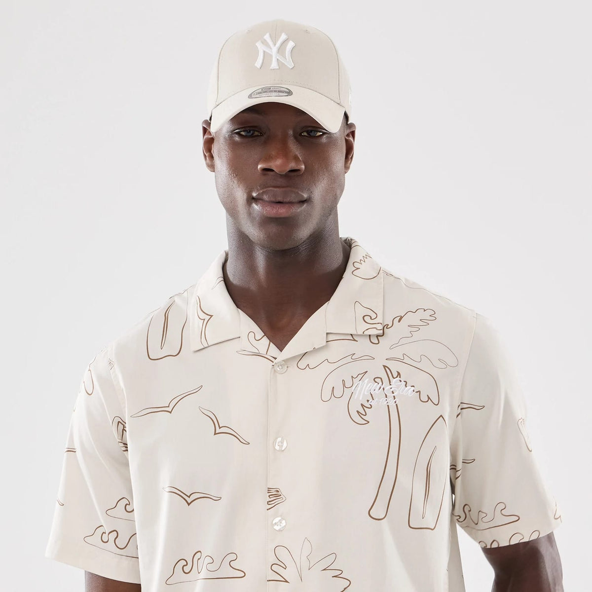 The model is wearing this New Era Resort Short Sleeve Shirt in natural. 7