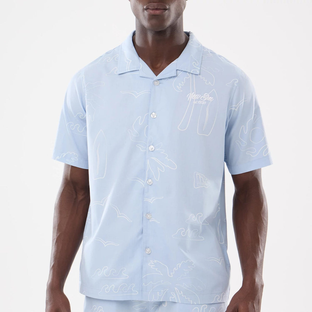 The model is wearing this New Era Resort Short Sleeve Shirt in blue. 3